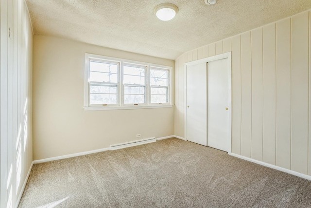 unfurnished bedroom featuring carpet flooring, a closet, a baseboard radiator, and a textured ceiling