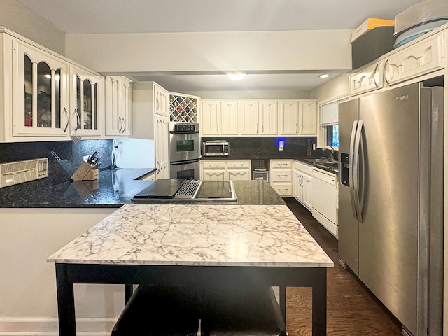 kitchen featuring sink, dark wood-type flooring, decorative backsplash, white cabinets, and appliances with stainless steel finishes