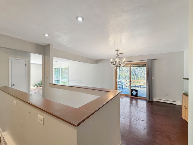 kitchen with a baseboard radiator, hanging light fixtures, dark wood-type flooring, and a notable chandelier