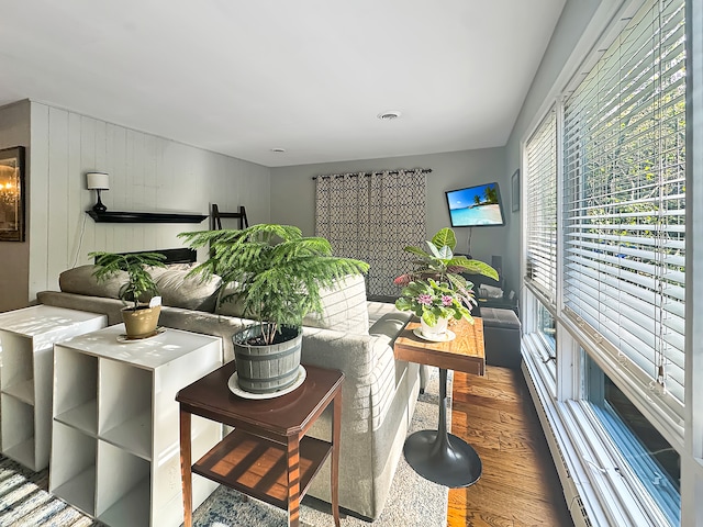 living room featuring wood-type flooring and wooden walls