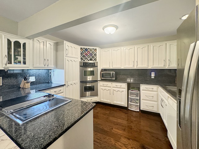 kitchen with white cabinets, decorative backsplash, stainless steel appliances, and dark wood-type flooring