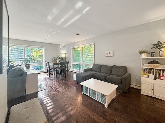 living room featuring baseboard heating, a wealth of natural light, and dark wood-type flooring