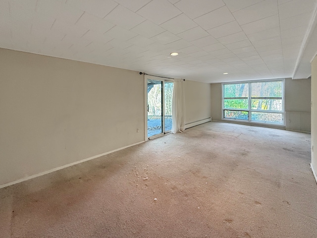 carpeted spare room with a baseboard radiator