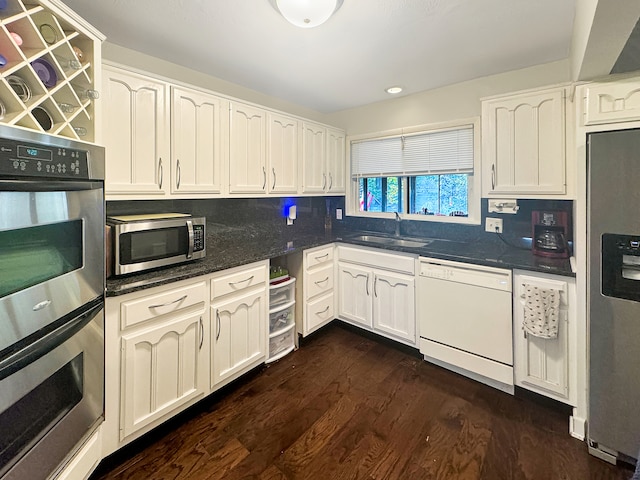 kitchen featuring tasteful backsplash, stainless steel appliances, sink, dark hardwood / wood-style floors, and white cabinetry