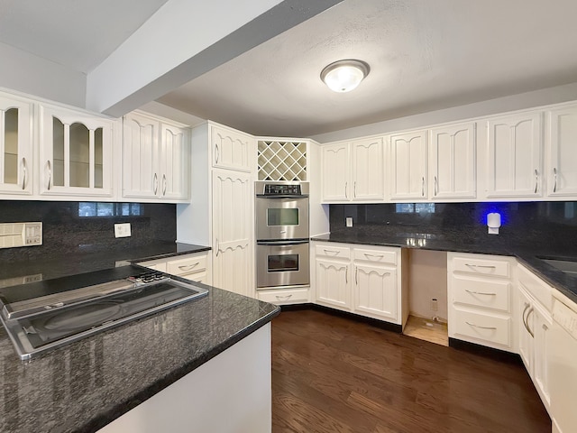 kitchen with backsplash, white cabinetry, stainless steel double oven, and dark wood-type flooring