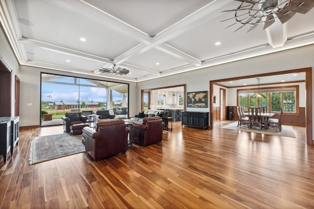 living room featuring beamed ceiling, hardwood / wood-style flooring, ceiling fan, and coffered ceiling