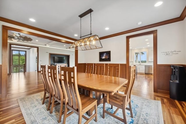 dining room with crown molding, ceiling fan, and light wood-type flooring