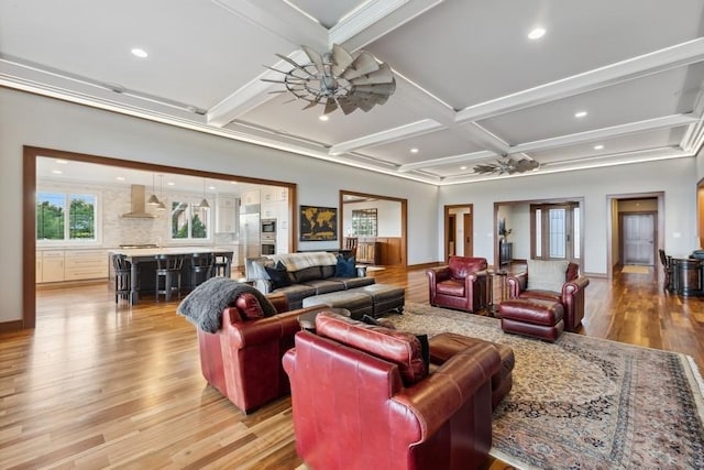 living room featuring beamed ceiling, light hardwood / wood-style floors, ceiling fan, and coffered ceiling