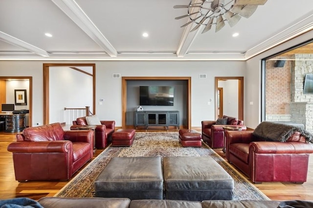 living room with ceiling fan, beam ceiling, crown molding, and light hardwood / wood-style flooring