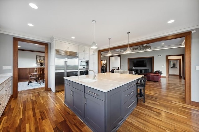 kitchen featuring gray cabinetry, white cabinetry, built in appliances, pendant lighting, and ornamental molding