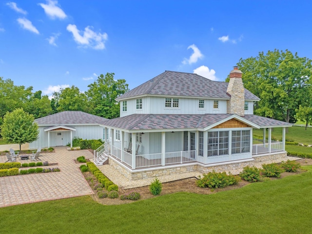 rear view of house featuring a sunroom, a patio area, and a yard