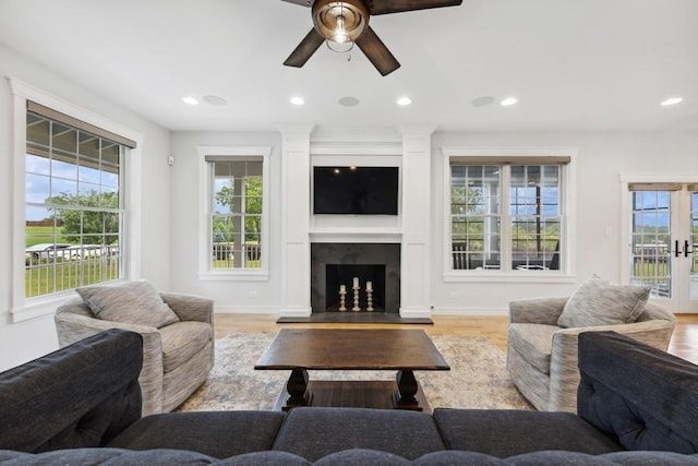 living room featuring ceiling fan, light hardwood / wood-style floors, and french doors