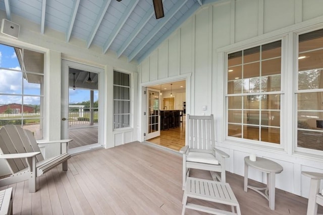 sunroom / solarium featuring vaulted ceiling with beams and ceiling fan