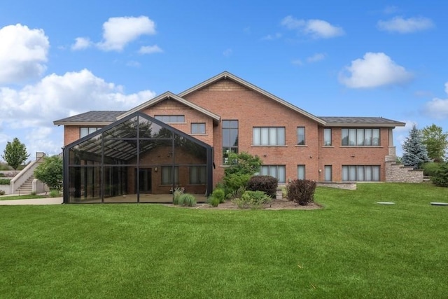 rear view of house with glass enclosure and a yard