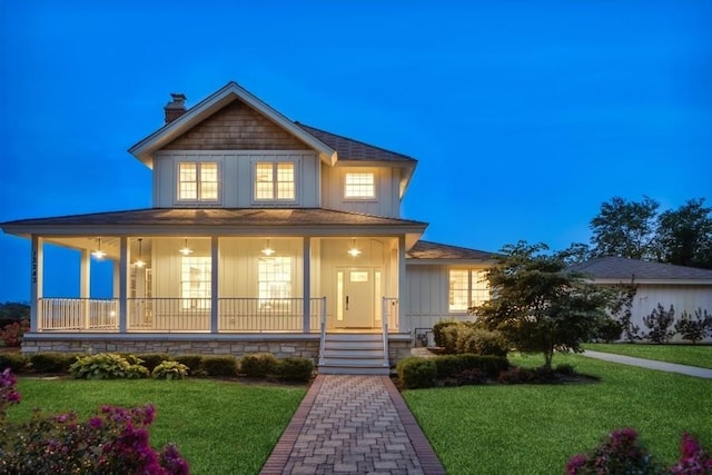 country-style home with a lawn and covered porch