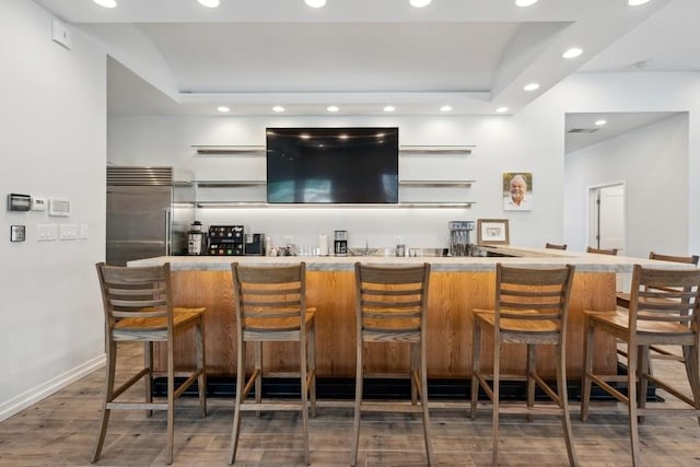 bar with built in fridge and dark hardwood / wood-style flooring