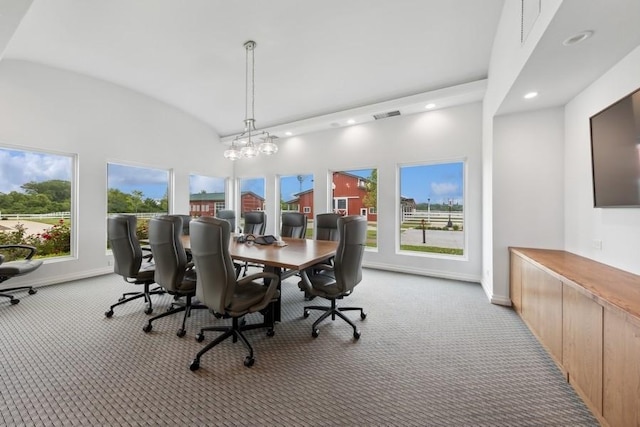 carpeted dining space with lofted ceiling