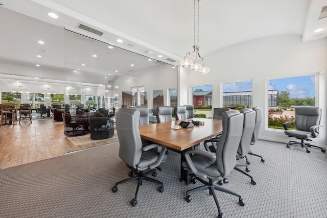 carpeted dining room with lofted ceiling and a notable chandelier