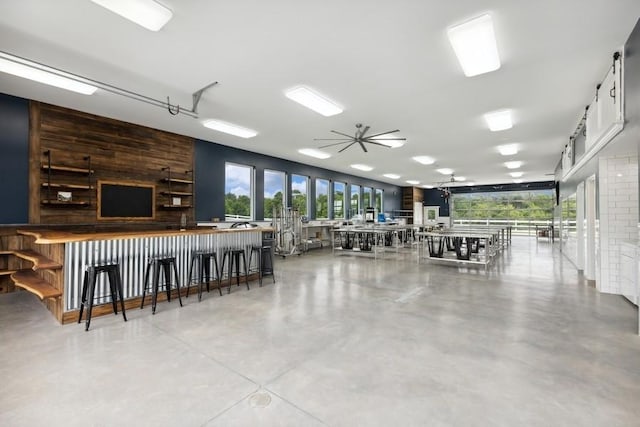 interior space with white cabinets, plenty of natural light, ceiling fan, and concrete floors