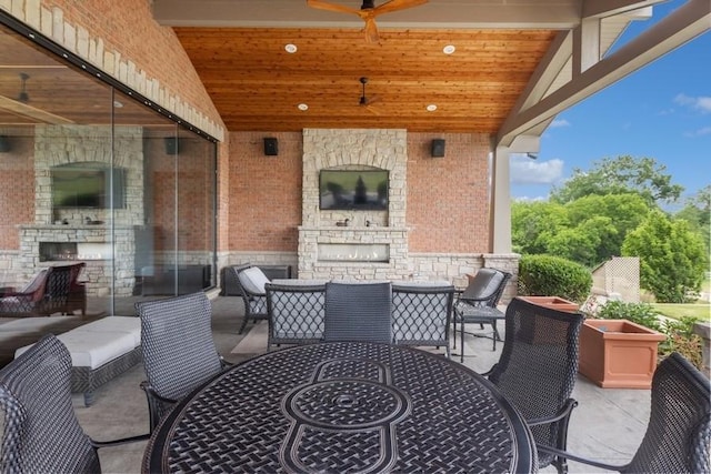 view of patio / terrace with ceiling fan and an outdoor fireplace