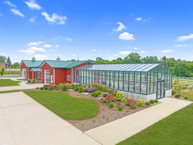 view of property's community featuring a lawn and an outbuilding