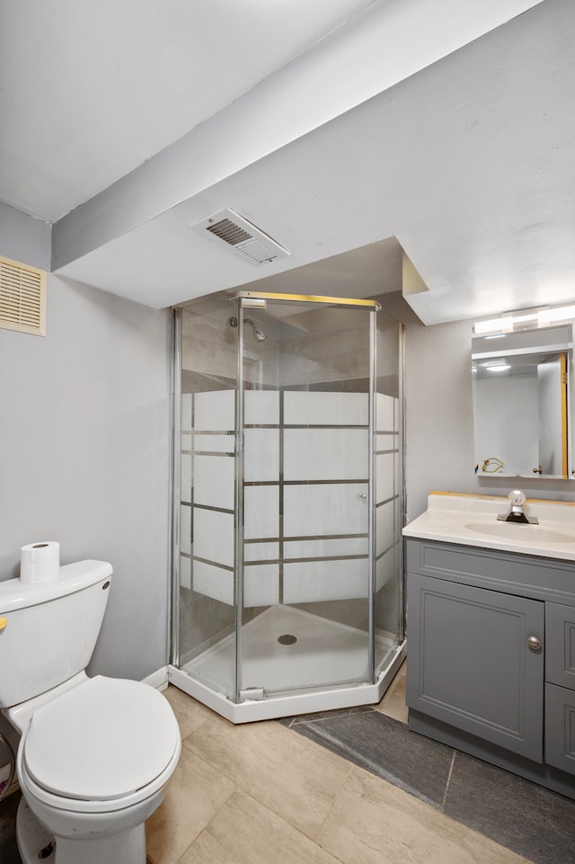 bathroom featuring vanity, toilet, tile patterned floors, and an enclosed shower