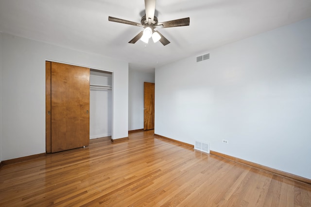 unfurnished bedroom with a closet, light wood-type flooring, and ceiling fan