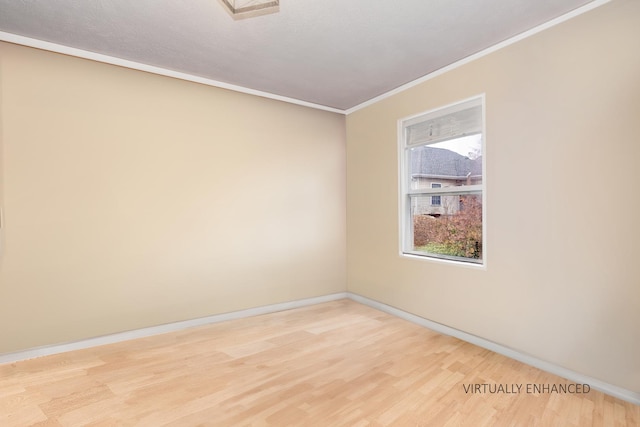 spare room featuring light wood-type flooring and ornamental molding