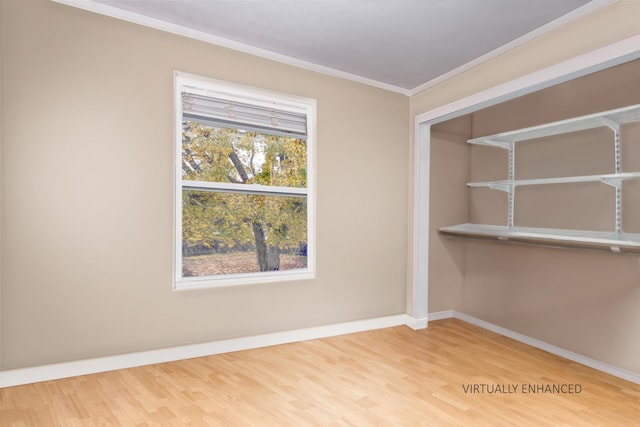 spare room featuring wood-type flooring and crown molding