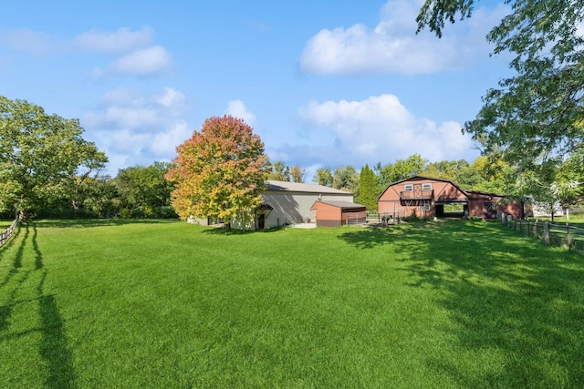 view of yard with an outbuilding, a pole building, and fence