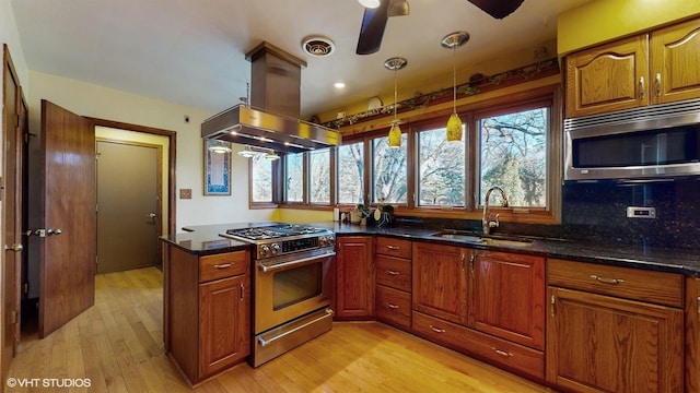 kitchen with island range hood, visible vents, brown cabinetry, appliances with stainless steel finishes, and a sink