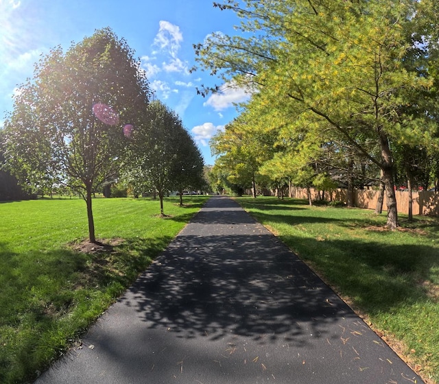 view of property's community with a lawn and fence