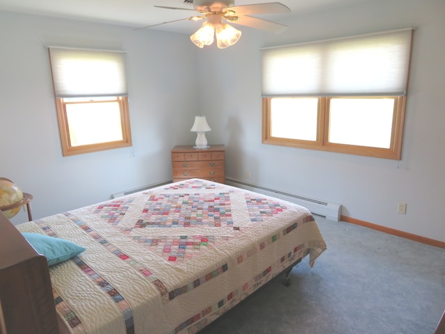 bedroom featuring a baseboard radiator, multiple windows, and ceiling fan