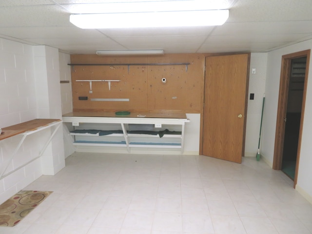 basement with a workshop area and a drop ceiling