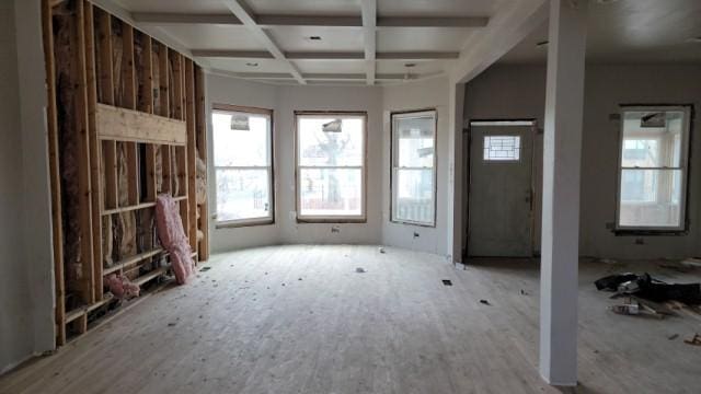 unfurnished living room featuring beamed ceiling, light hardwood / wood-style flooring, and coffered ceiling