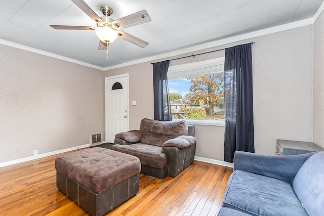 living room featuring crown molding, wood-type flooring, and ceiling fan