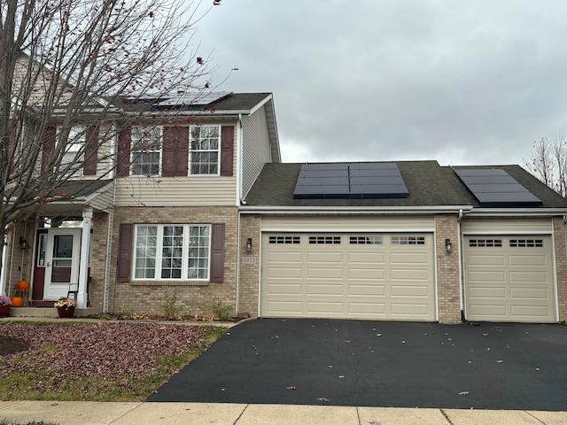 view of front of home featuring solar panels and a garage