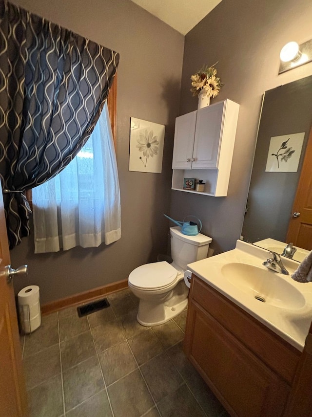 bathroom featuring toilet, vanity, and tile patterned flooring