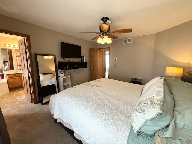 carpeted bedroom featuring ensuite bath and ceiling fan