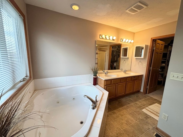 bathroom featuring vanity, a textured ceiling, separate shower and tub, and tile patterned flooring