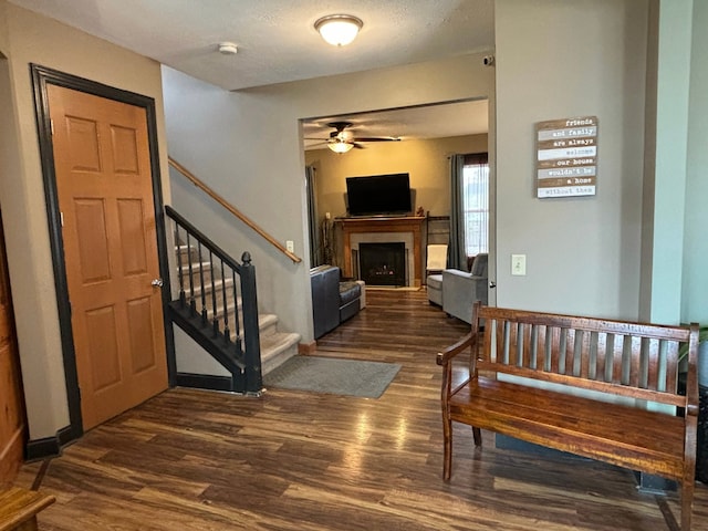 entrance foyer featuring ceiling fan, a textured ceiling, and dark hardwood / wood-style floors