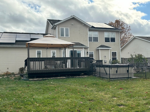 back of property with a wooden deck, a gazebo, and a yard