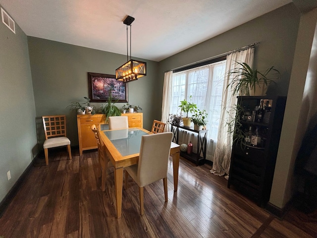 dining area with an inviting chandelier and dark hardwood / wood-style floors