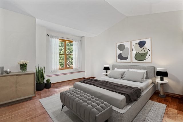 bedroom featuring hardwood / wood-style flooring and lofted ceiling