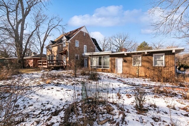 view of snow covered rear of property