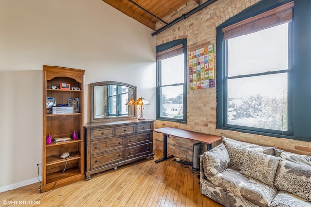 sitting room featuring brick wall, lofted ceiling with beams, wood ceiling, and light hardwood / wood-style floors