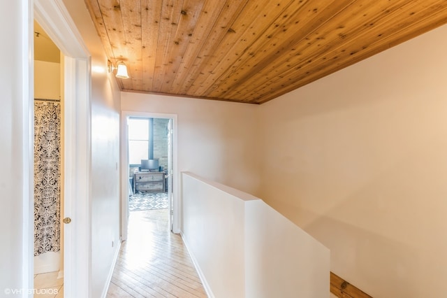 corridor with wood ceiling and light hardwood / wood-style flooring