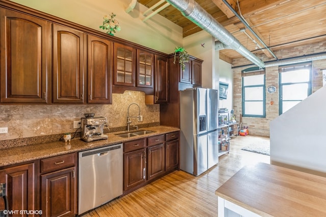 kitchen featuring appliances with stainless steel finishes, sink, wood ceiling, dark stone counters, and light hardwood / wood-style flooring