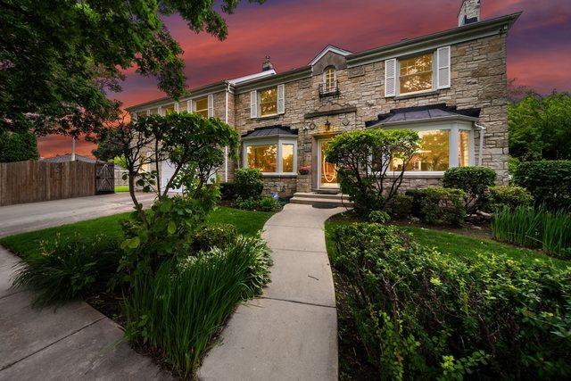 view of front of home featuring stone siding and fence