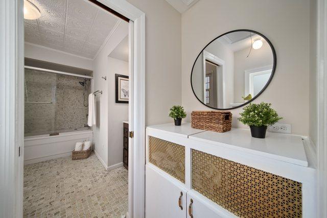 full bath with crown molding, baseboards, and enclosed tub / shower combo